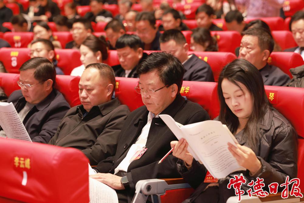 與會(huì)代表認(rèn)真閱讀政府工作報(bào)告